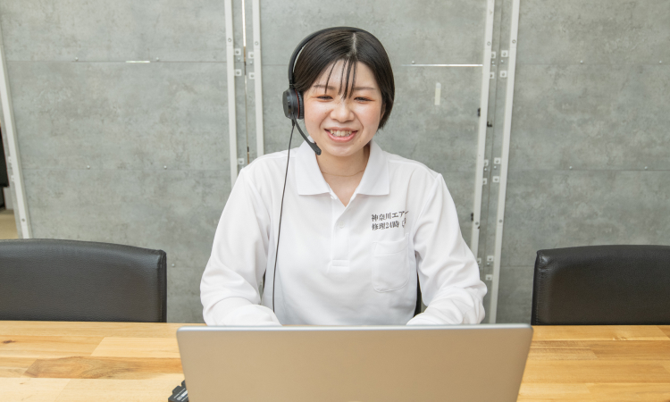 笑顔でパソコンの前で話す女性