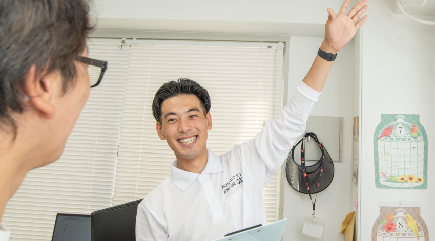 男性が笑顔でお客様に応対している